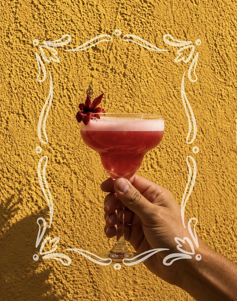 A cocktail against the saffron wall at TAPEO